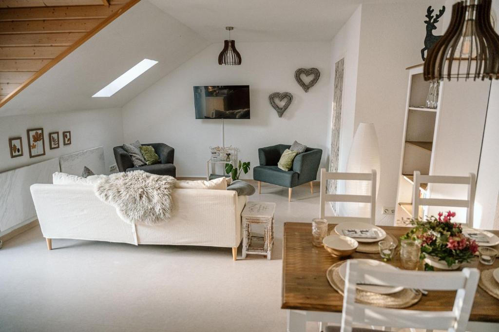 a living room with a white couch and a table at Ferienwohnung Landliebe in Pfullendorf