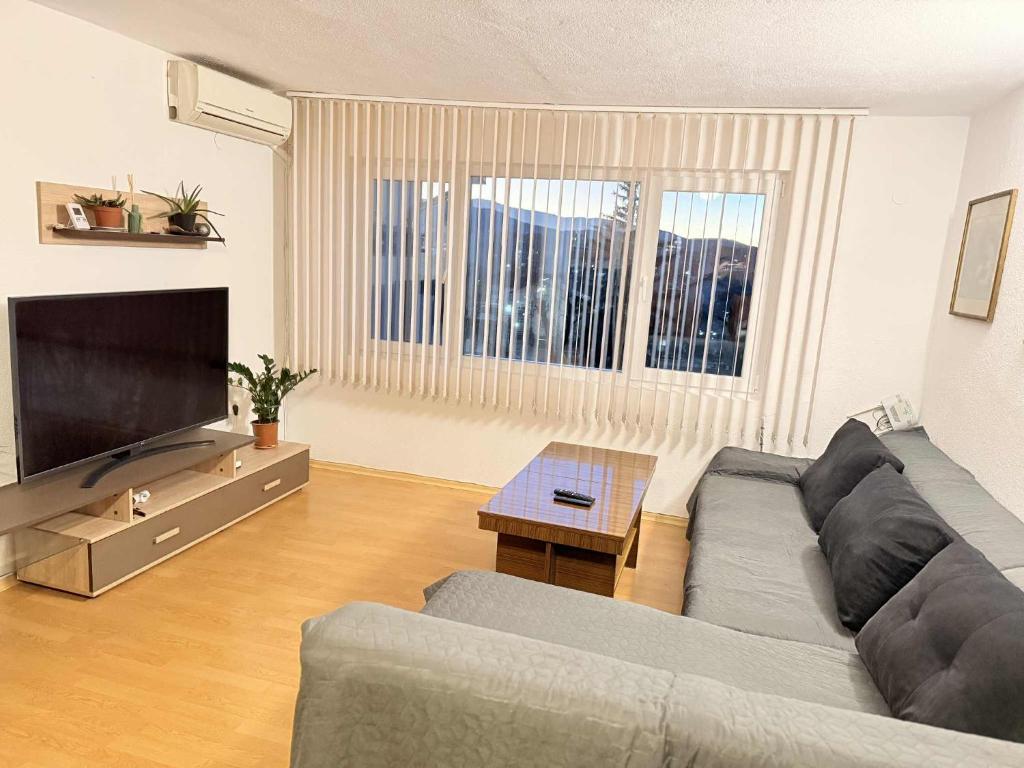 a living room with a couch and a flat screen tv at Cozy two room maisonette apartment in Samokov
