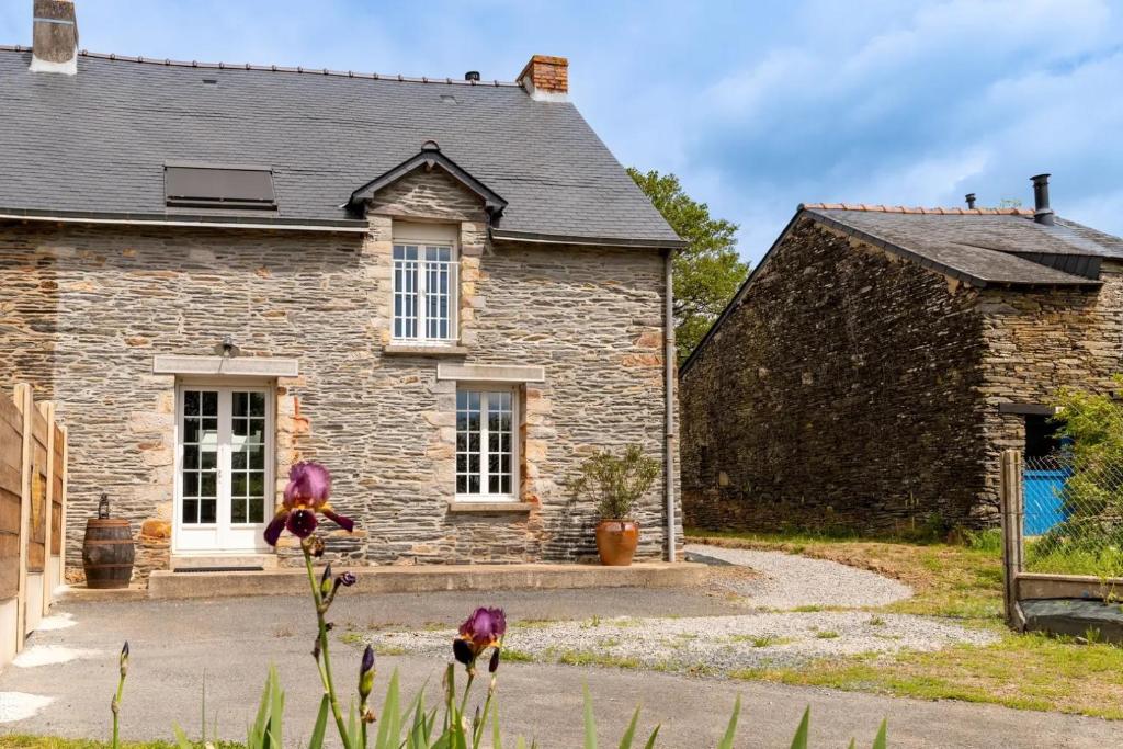 une vieille maison en pierre avec un jardin devant dans l'établissement Les palis de Sert, à La Chapelle-de-Brain