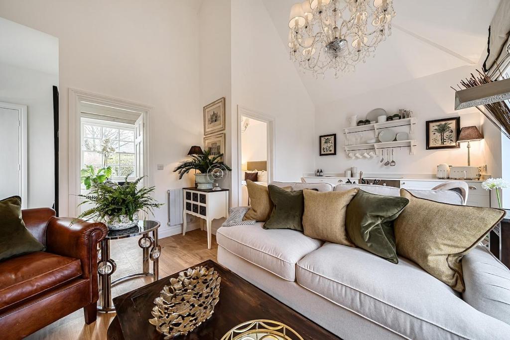 巴斯The Coach House at The Grange的带沙发和枝形吊灯的客厅