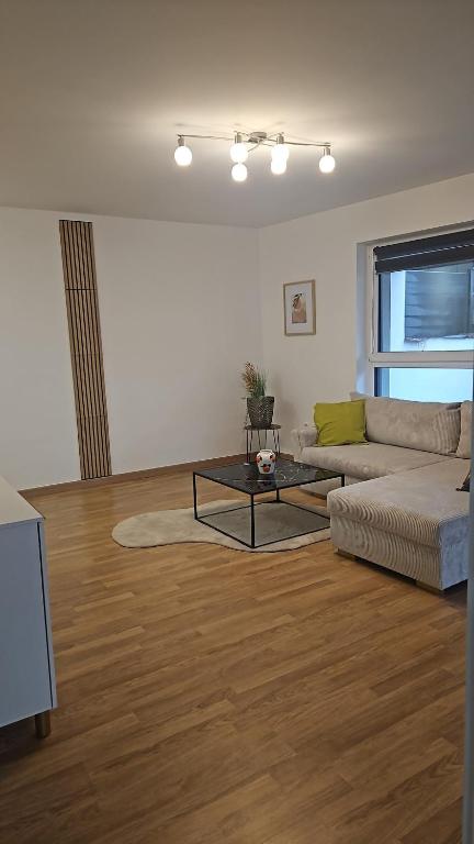 a living room with a couch and a table at Bright apartment, private parking in Dudelange