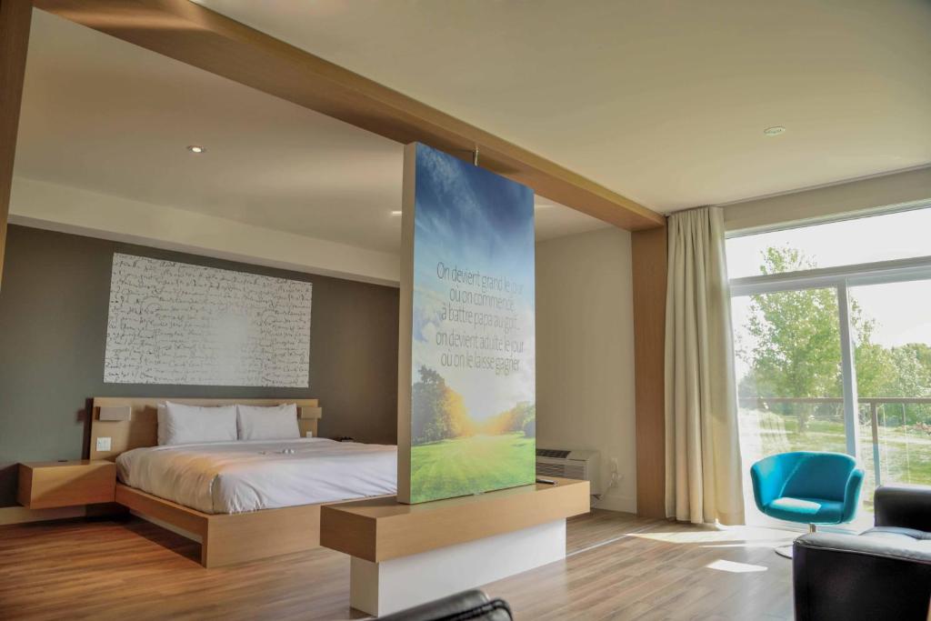 1 dormitorio con cama y pantalla grande en La Cache du Golf, en Beauceville