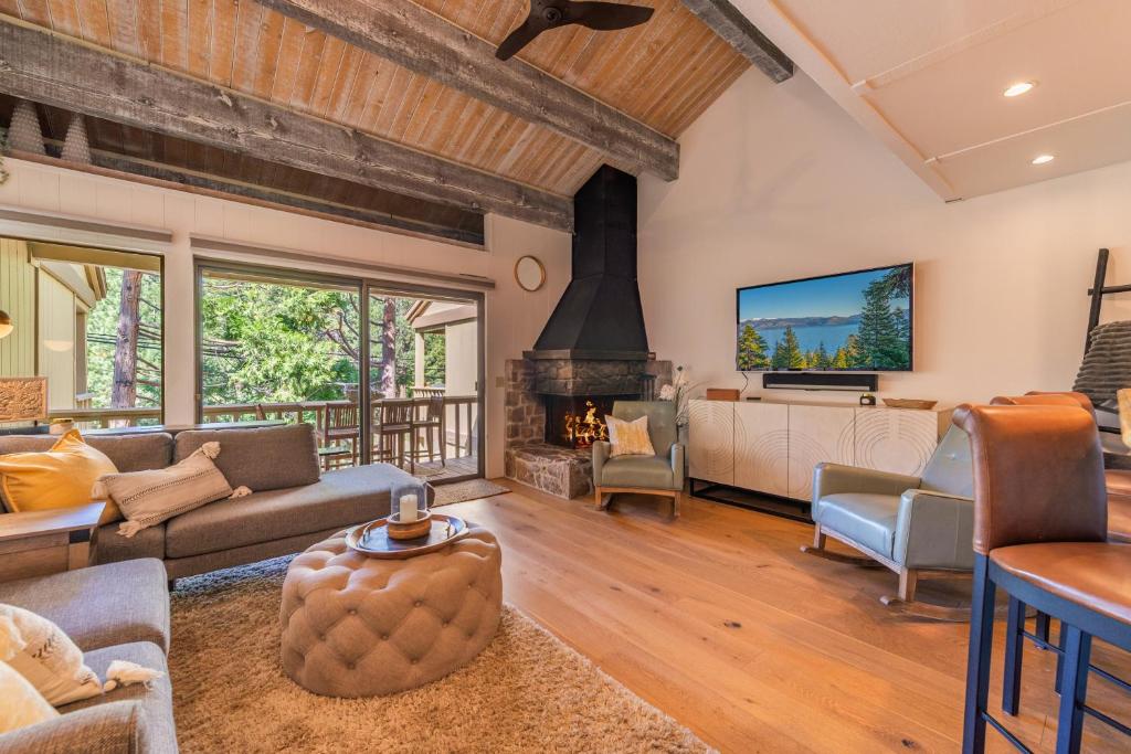 een woonkamer met een bank en een open haard bij Kings Beach Luxe in Wood Vista