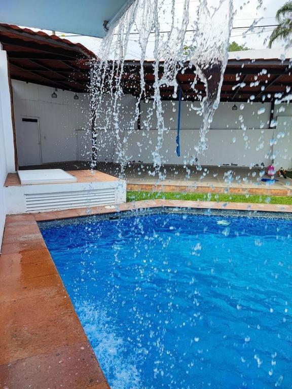 a swimming pool with a water fountain at Casa Jarana in Oaxtepec