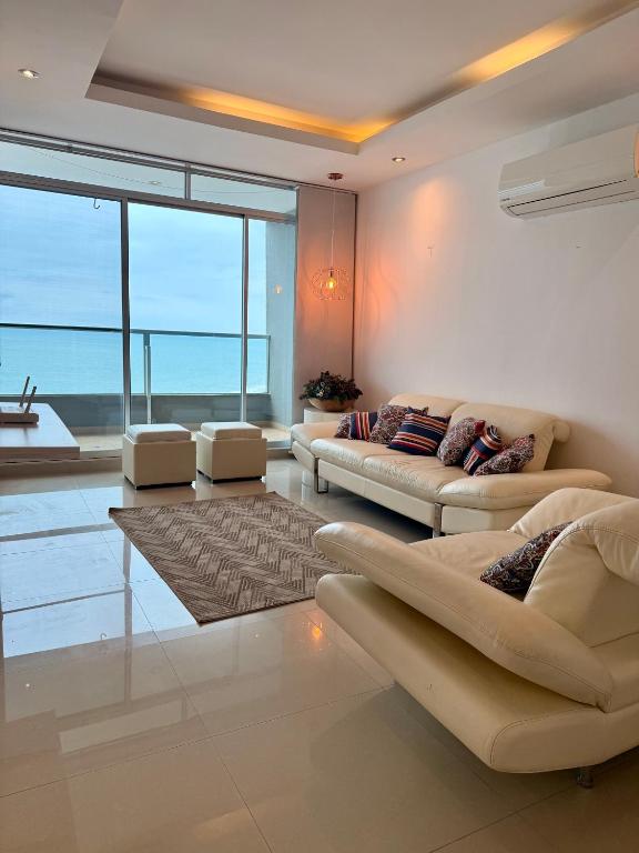 a living room with two couches and a large window at Departamento Diamond Beach Tonsupa in Tonsupa