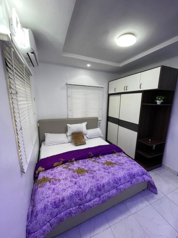 een slaapkamer met een groot bed met paarse lakens bij Luxury Stay in Lagos in Iju Junction