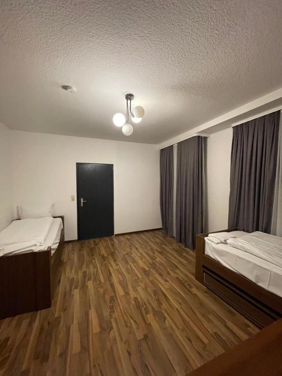 an empty room with two beds and a door at Hostel Casa Andalucia in Hallbergmoos