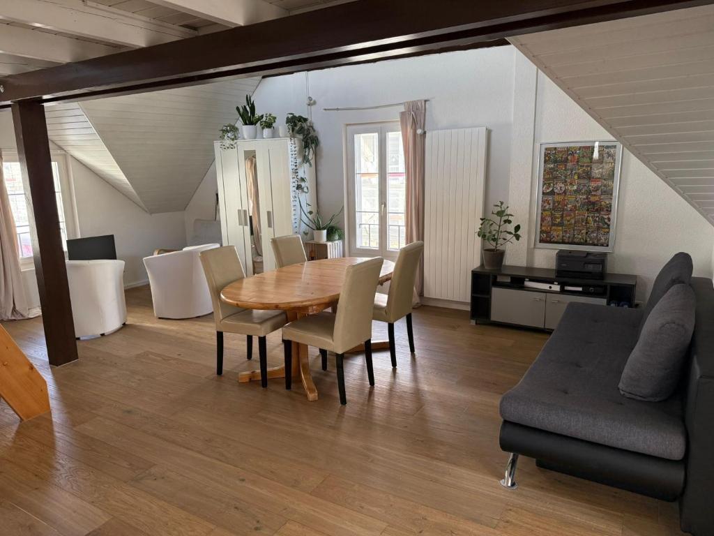 Una sala de estar con una mesa y sillas de madera. en Apartment in Düdingen, en Düdingen