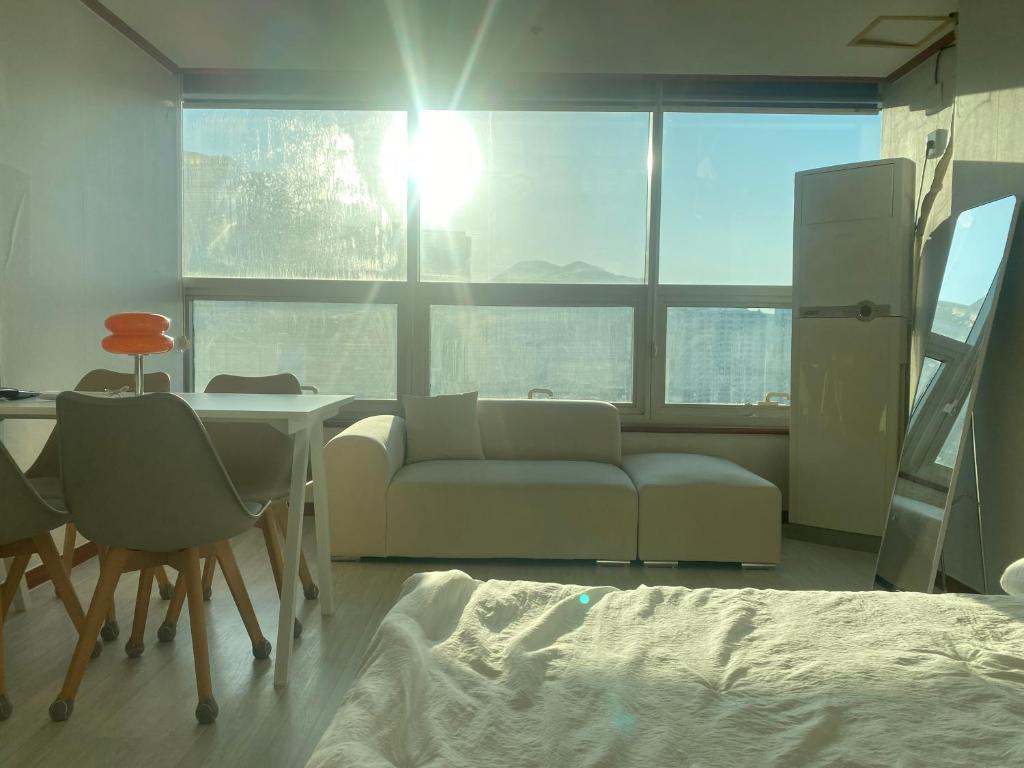 una sala de estar con un sofá y una mesa en 범계역2분 거리 퀸침대2개 무료주차가능 뚫린뷰가 일품, 