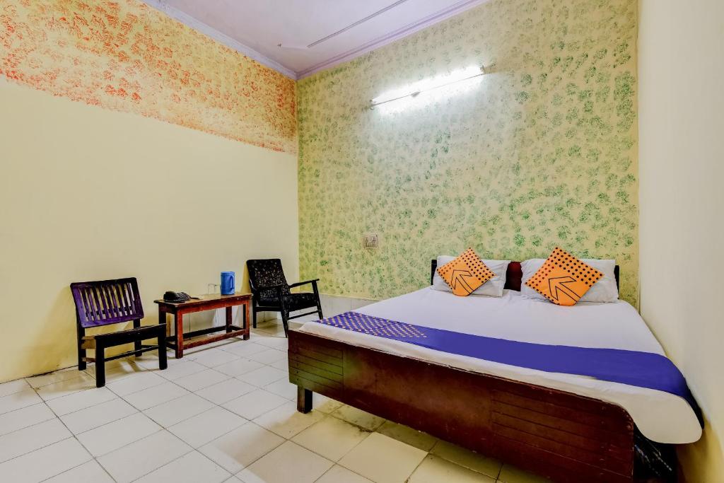 Un dormitorio con una cama y dos sillas. en Spot On Swagat Palace, en Nueva Delhi