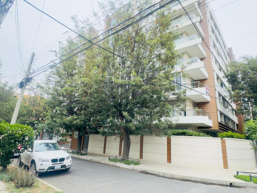 Familiar y equipado a pasos del Cine Center في كوتشابامبا: سيارة متوقفة على شارع امام مبنى