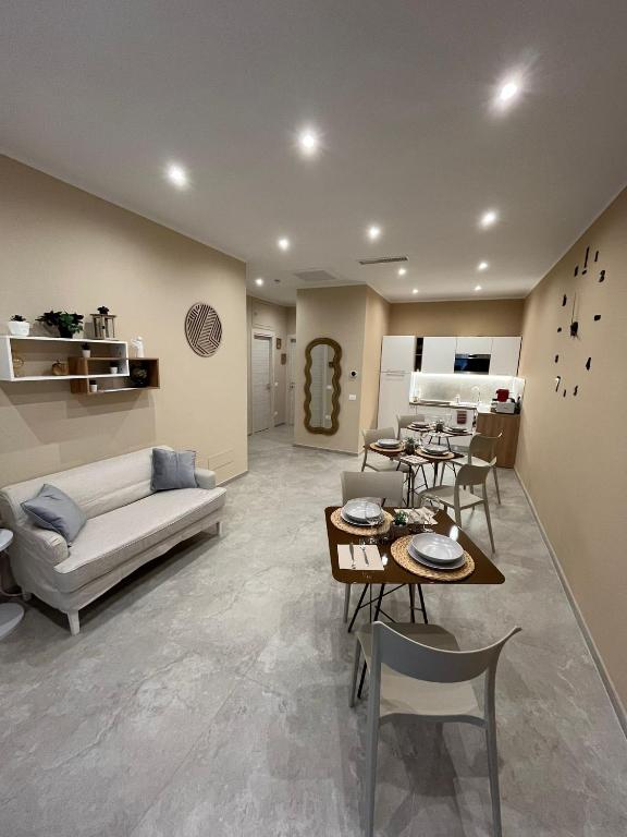 a living room with a couch and a table and chairs at G&Ghomeciampinosuite in Ciampino