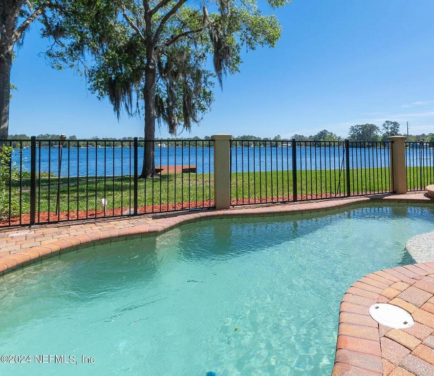 una piscina di fronte a una recinzione di Lakeside Retreat with pool, dock & game room a Interlachen