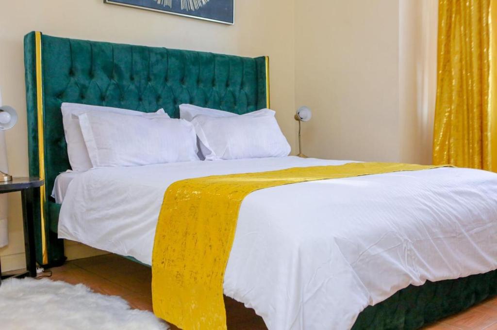 Homa BayAmors place的卧室里有一张大床，床头板是绿色的