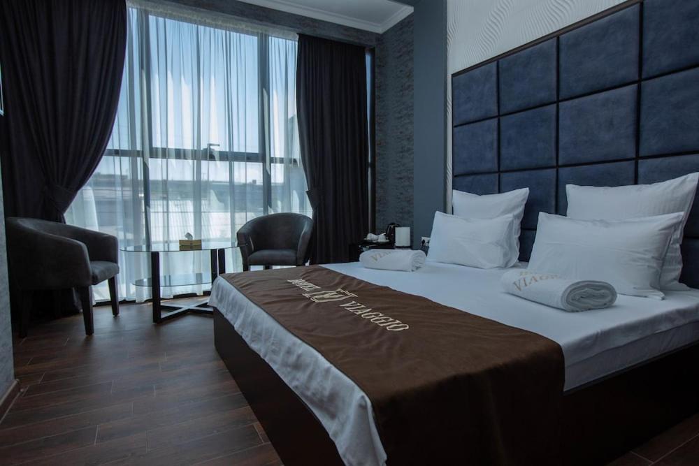 a bedroom with a large bed with a large window at V by Viaggio in Yerevan