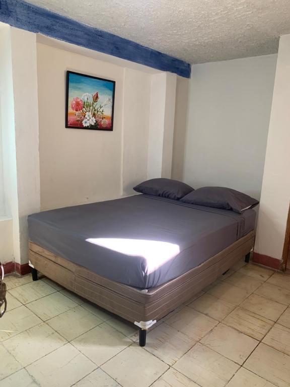 un lit dans une chambre avec un tableau sur le mur dans l'établissement Habitación Privada Casa Privada, à Granada