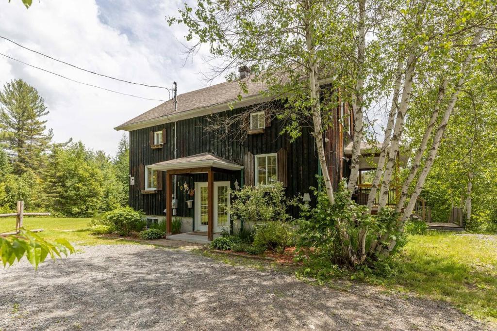 Una vieja casa negra con entrada para coches en Lake Views, Hot Tub, Fireplace and Pool Table, en Chertsey