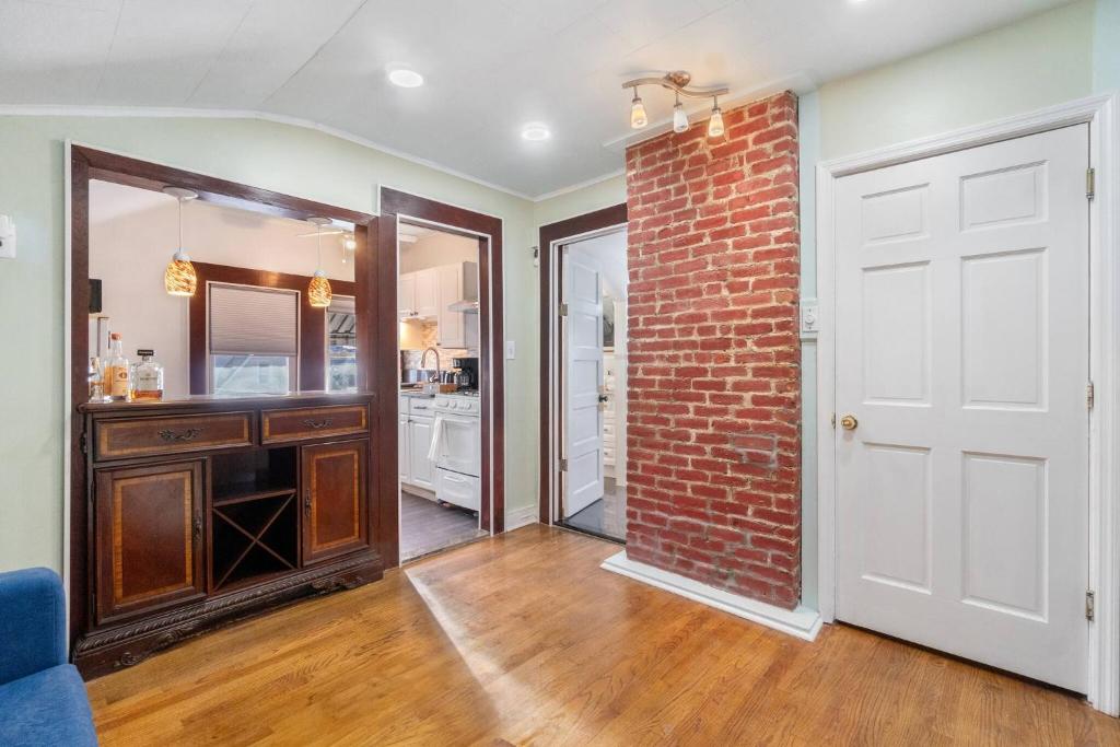 una camera con un muro di mattoni e una porta bianca di The City Climb a Guttenberg