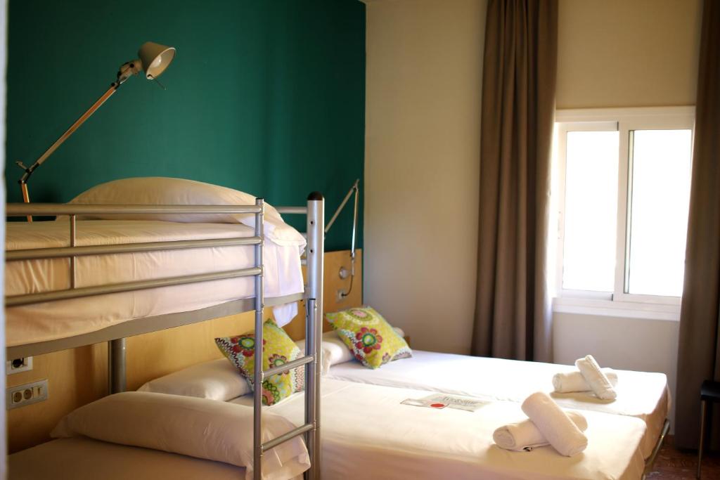 Postel nebo postele na pokoji v ubytování Hostal La Fosca