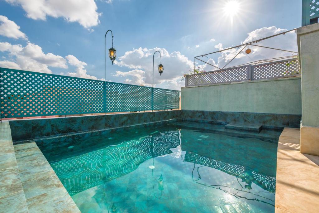 - une piscine au soleil réfléchissant dans l'eau dans l'établissement Riad Diamond Of Marrakech & Spa, à Marrakech