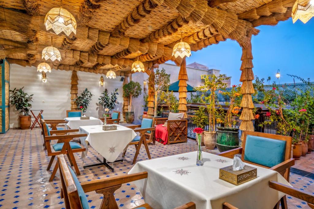 un restaurant avec des tables et des chaises et un plafond en bois dans l'établissement Riad Diamond Of Marrakech & Spa, à Marrakech