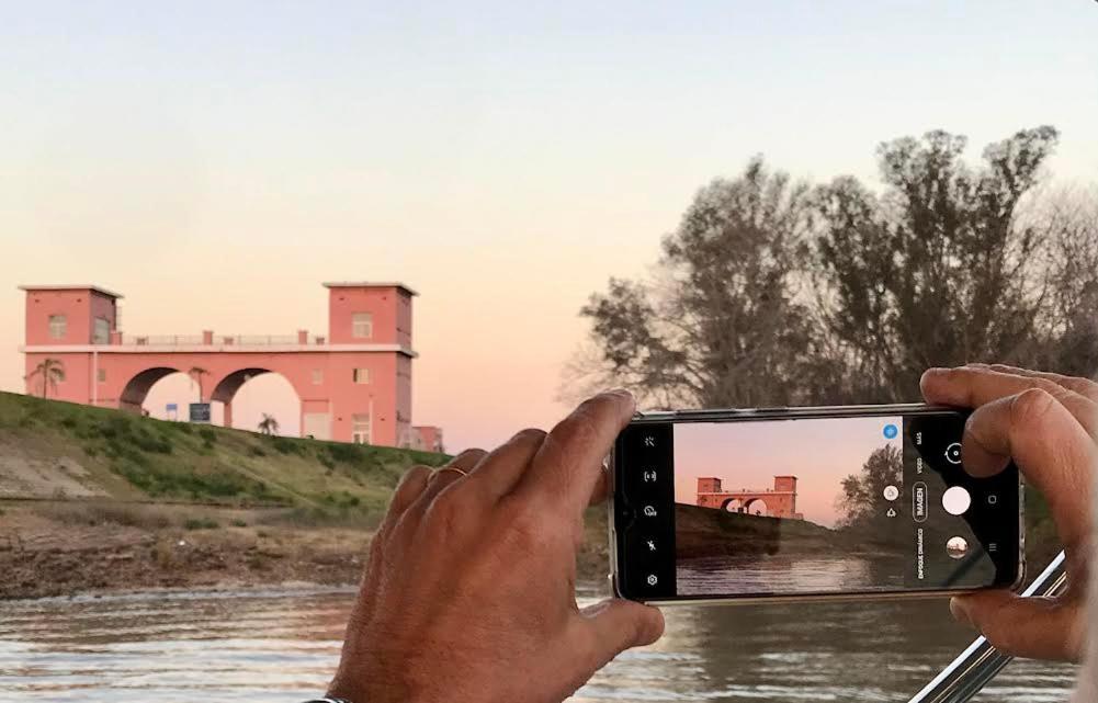 iemand die met een mobiele telefoon een foto van een rivier maakt bij MorenoPLAZA in Concepción del Uruguay