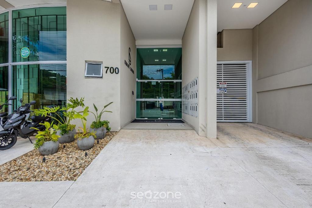 a building entrance with a motorcycle parked outside of it at Sua estadia completa a poucos minutos do mar em BC – STLs in Balneário Camboriú
