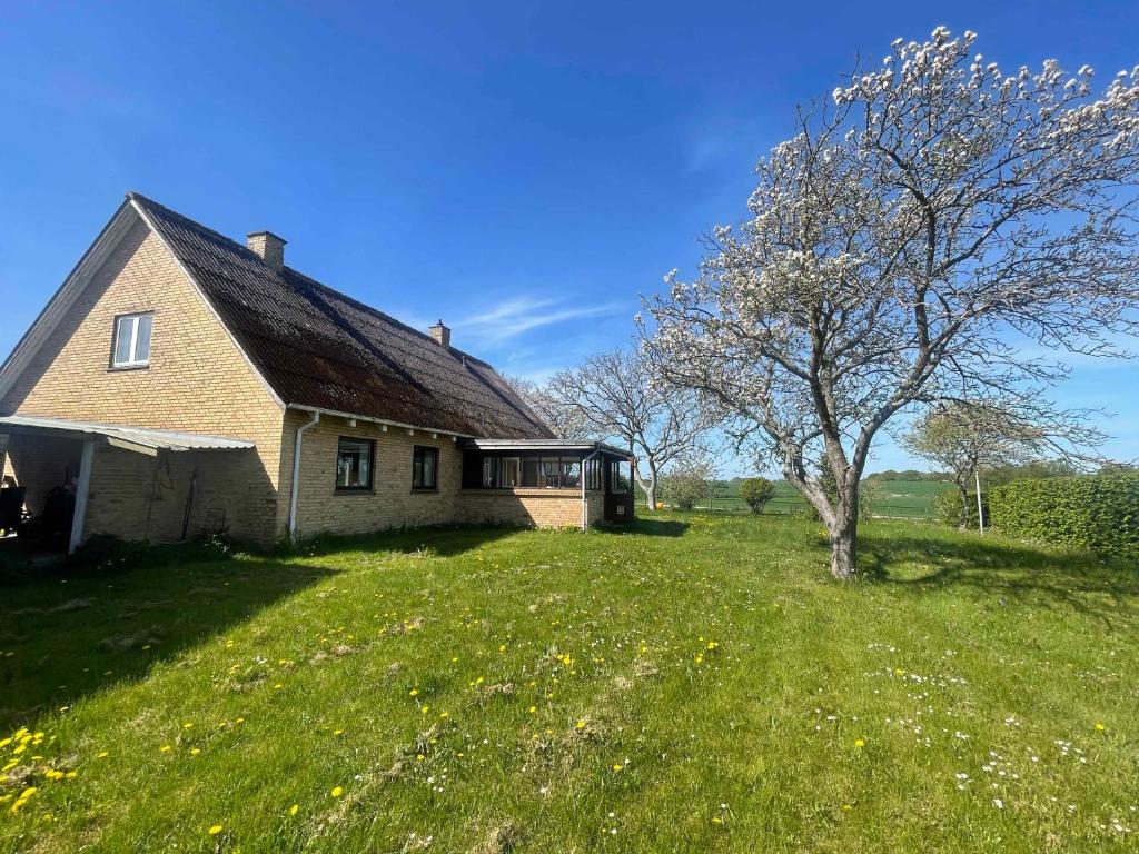 an old house in a field with a tree at Renovated Country Home 50 M From The Sea in Blans