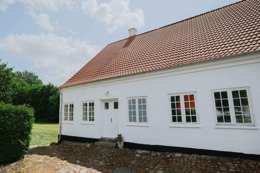 a white house with a red roof at Stay In Hindemaes Historic Managers House in Ullerslev
