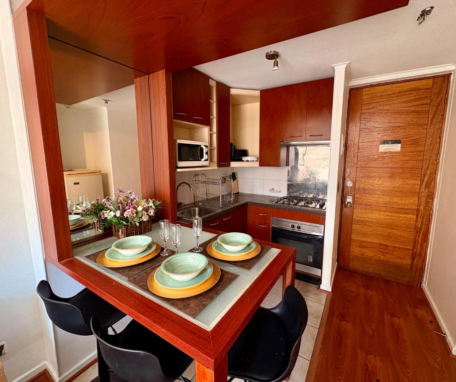 a kitchen with a table with plates on it at Moderno Apartamento a pasos del Metro y Museo Bellas Artes, Cerro Santa Lucia, Barrio Lastarria in Santiago