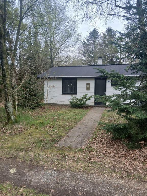 a white house with a driveway in a yard at Sommerhus I Ejerslev Lyng På Nord Mors in Ejerslev