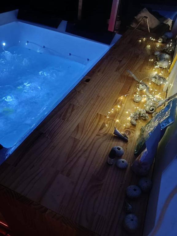 a swimming pool with candles and rocks on a wooden floor at Les zoliviers in Petite Rivière