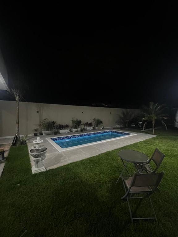 a swimming pool in a yard at night at Enseada Beach in São Sebastião