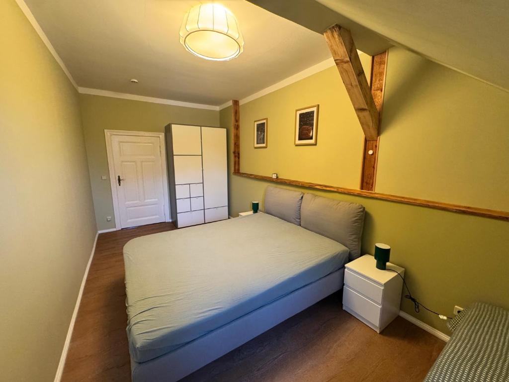 ein kleines Schlafzimmer mit einem Bett in einem Zimmer in der Unterkunft Altstadt Quartier in Bad Freienwalde
