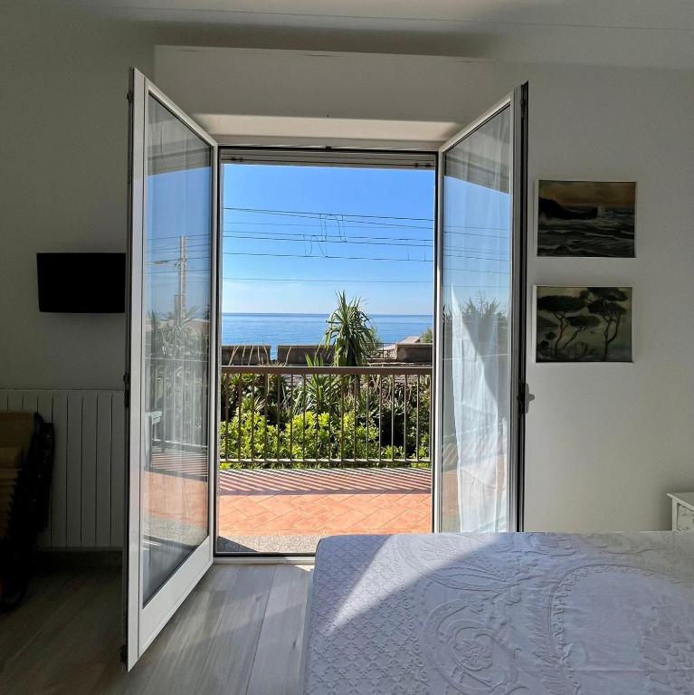 a bedroom with a glass door leading to a balcony at La vista Azzurra in Bordighera