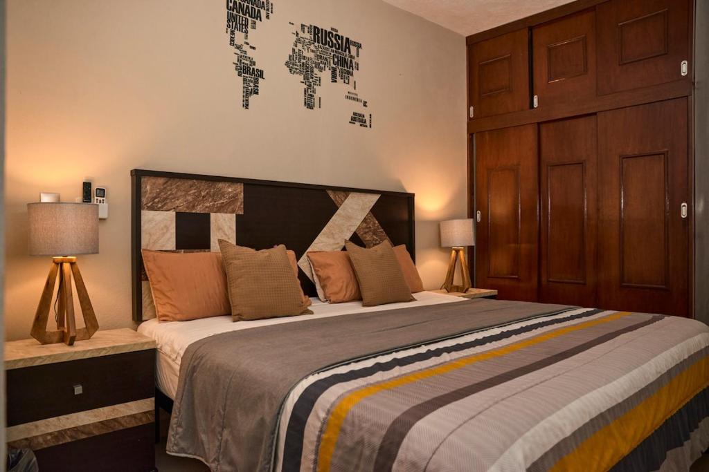 a bedroom with a large bed with two lamps at Casa almendros 31 in Ciudad Guzmán