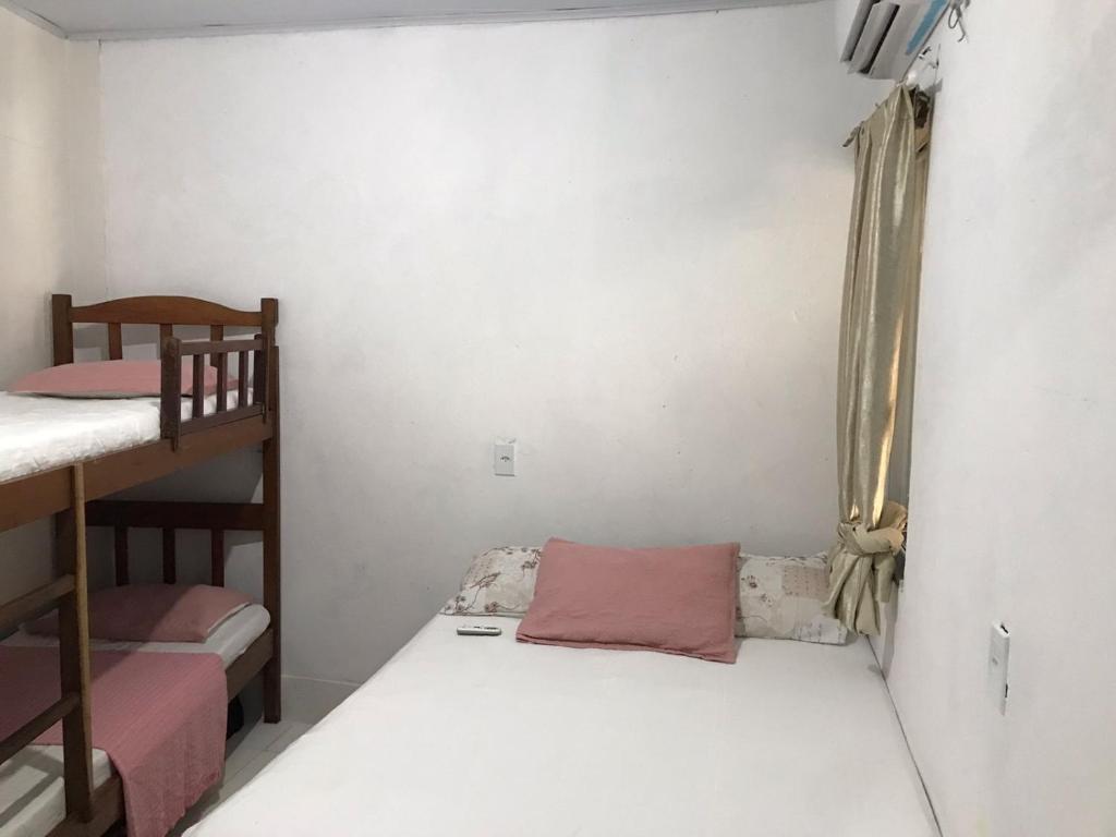 una piccola stanza con due letti a castello e una finestra di Casa Magalhães a Morro de São Paulo