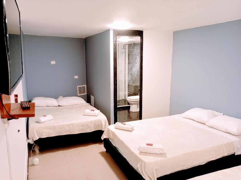 2 letti in una camera con bagno di Hotel Capitalino Central a Bogotá