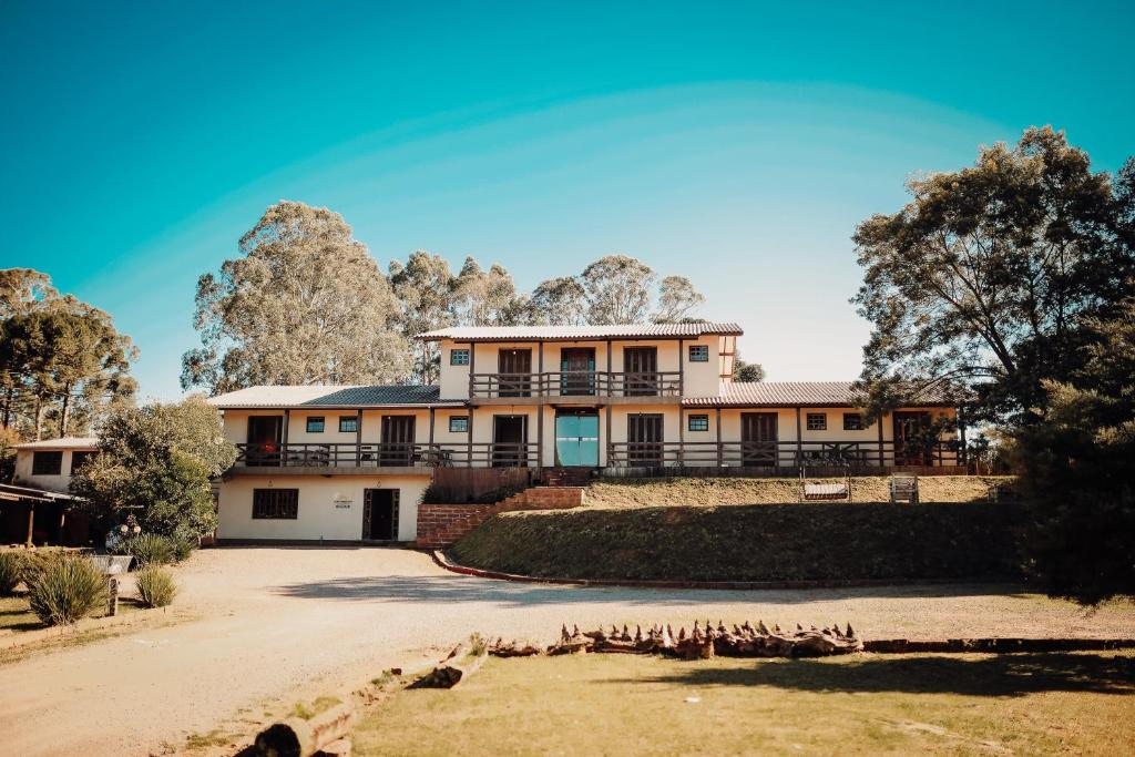 un’immagine di una casa con alberi sullo sfondo di Pousada Novo Horizonte a São Francisco de Paula