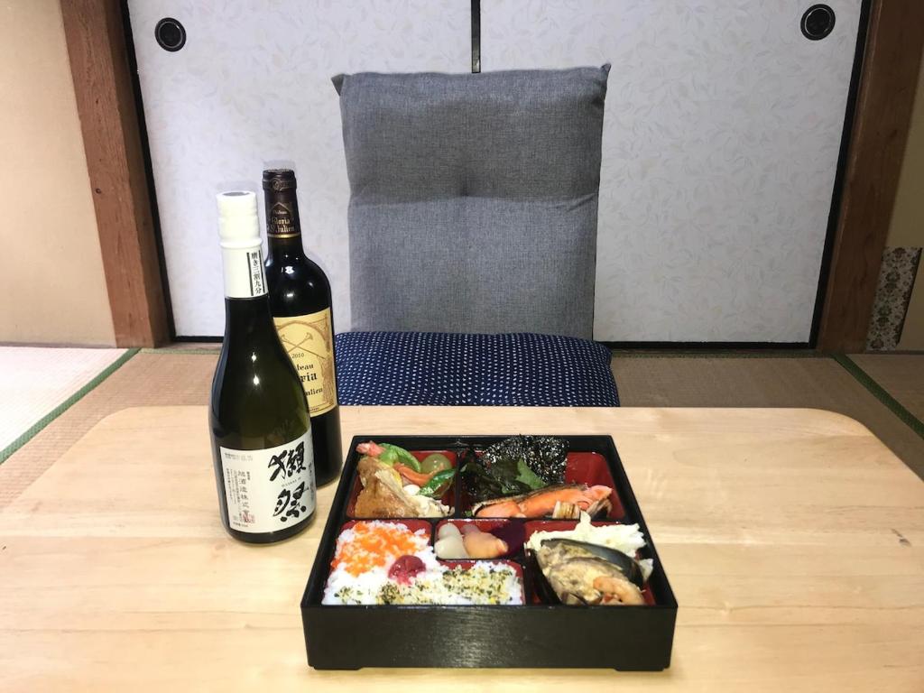 a plate of food and a bottle of wine on a table at YabFarm Lodge 102 in Kashiwa