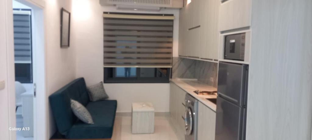 a small kitchen with a blue couch in a room at غزو 15 in Aydūn