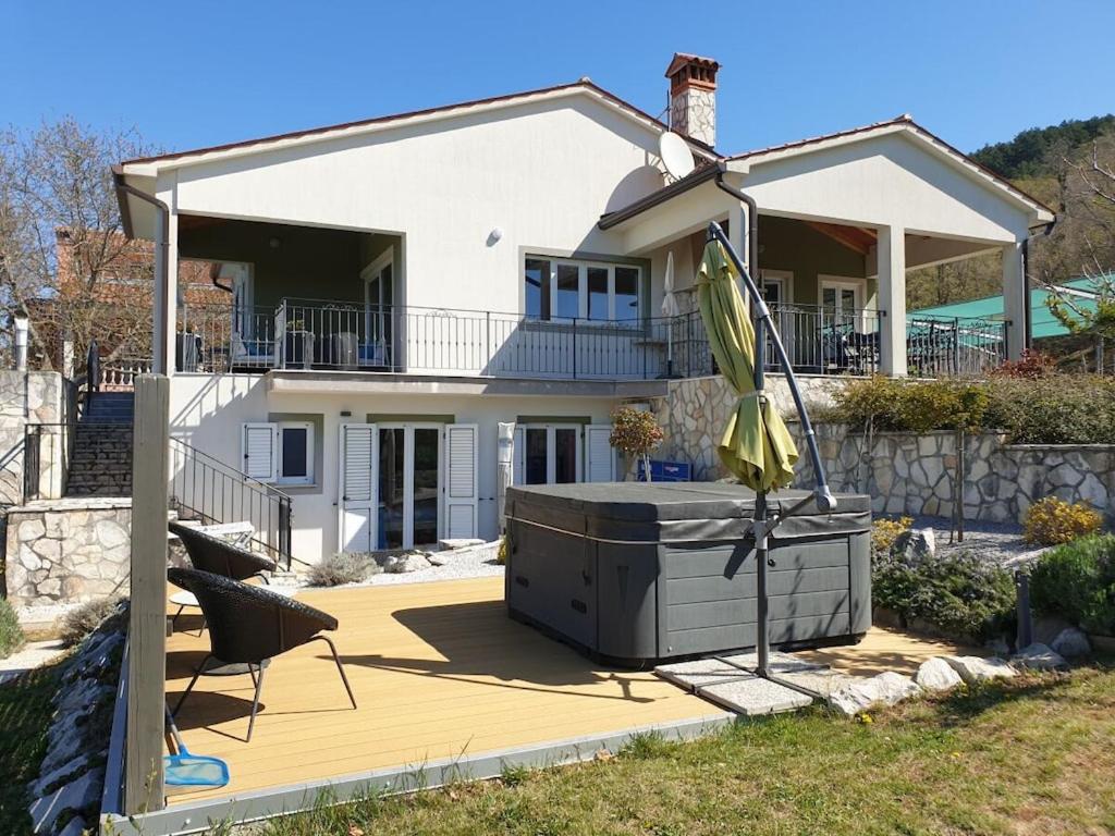 a house with a hot tub on a deck at Holiday home with 3 bedrooms in Ripenda Kras