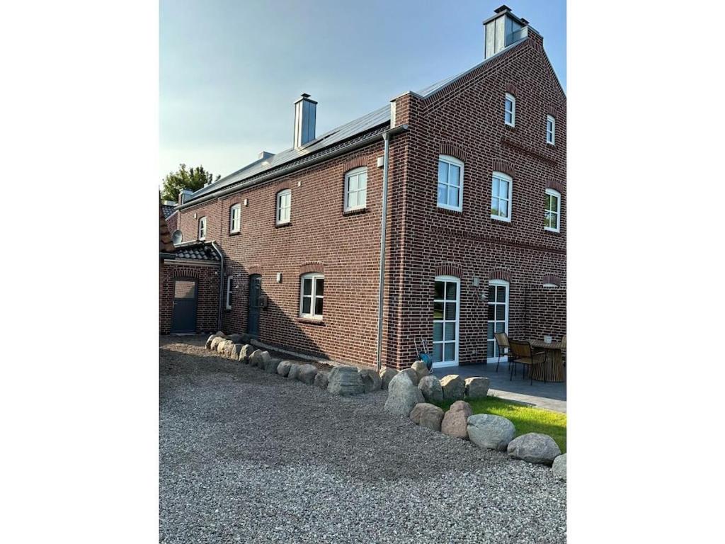 a brick building with a row of rocks in front of it at The Linnebargs, House 1 in Bisdorf