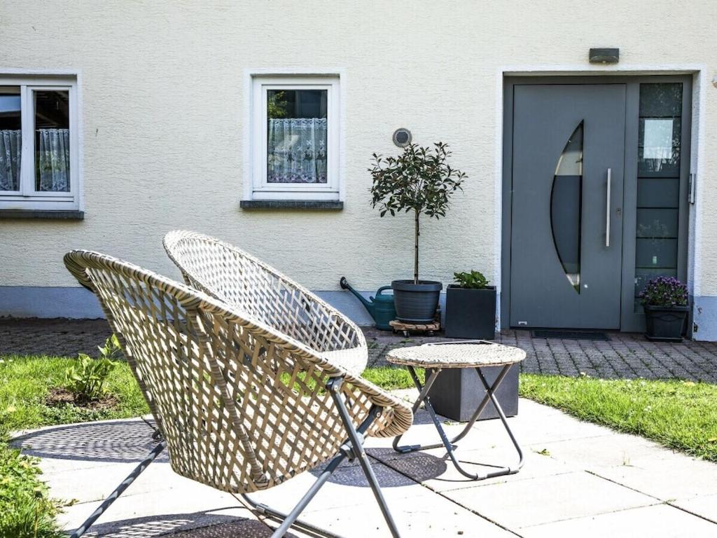 莫斯Holiday apartment in Moos with Wi-Fi的一对椅子和一张桌子在门前