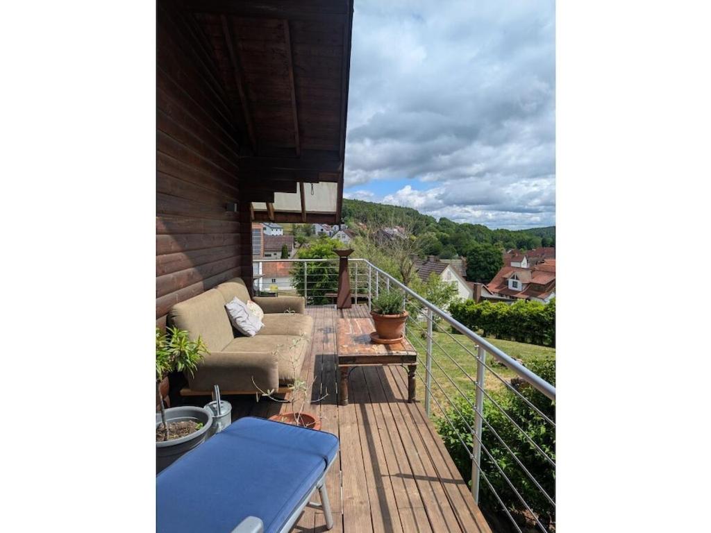 ein Balkon eines Hauses mit einer Couch und einem Tisch in der Unterkunft Holiday home Talblick 13 in Burgwallbach