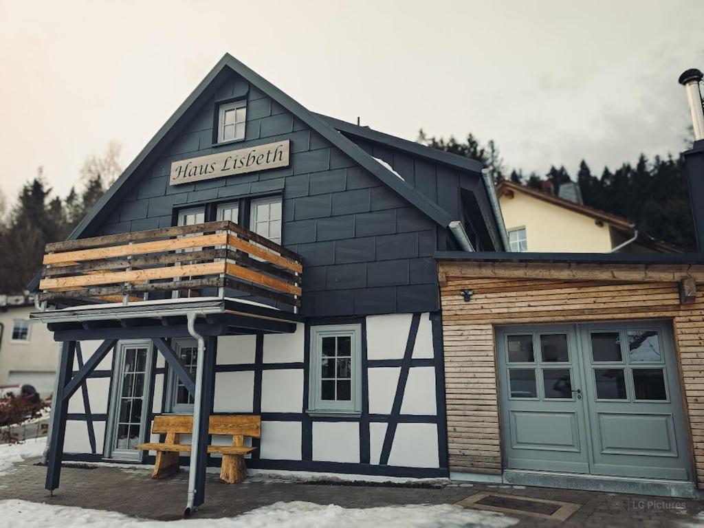 un edificio bianco e nero con tetto di House Lisbeth - Apartment Lina a Vesser