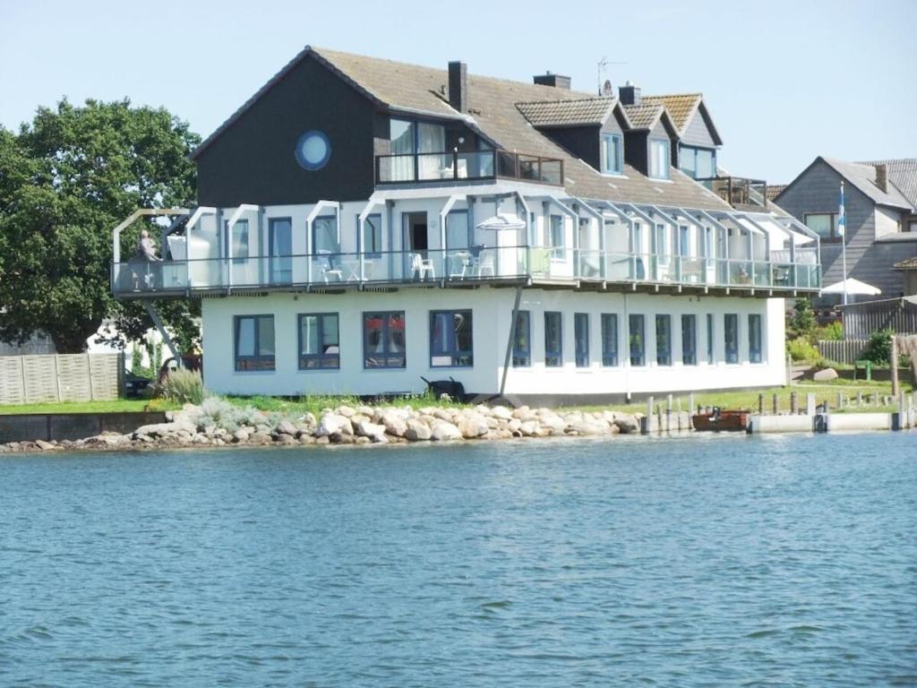 ein großes Haus am Ufer eines Wasserkörpers in der Unterkunft Holiday apartment with 1 bedroom in Maasholm