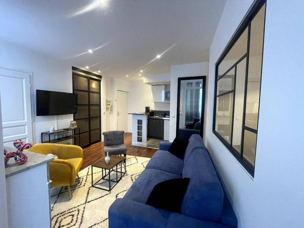 ein Wohnzimmer mit einer blauen Couch und einer Küche in der Unterkunft Le Cannet apartmment for 4 Guests in Tanneron