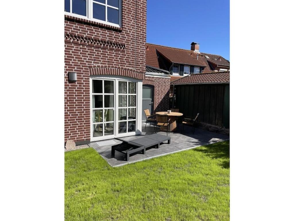 a patio with a bench and a table in front of a building at The Linnebargs, House 3 in Bisdorf