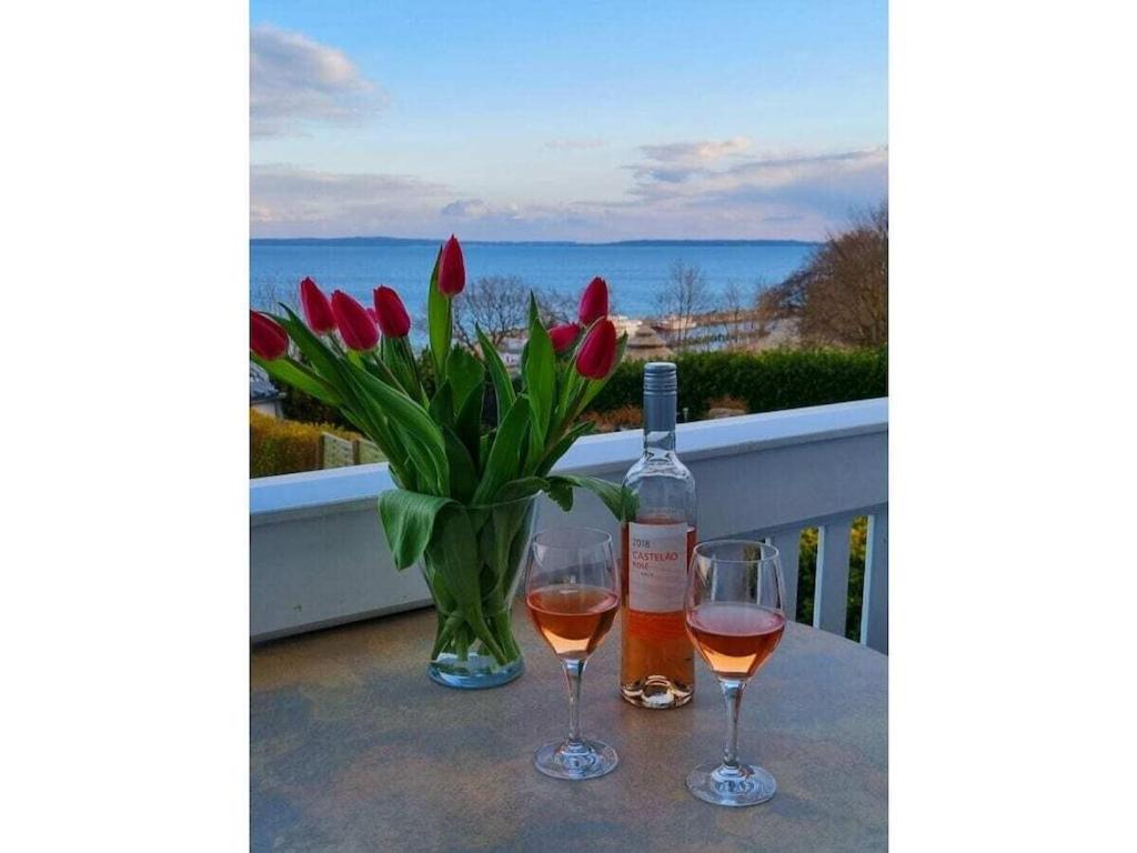 萨斯尼茨Holiday apartment with 2 bedrooms的一张桌子,上面放着两杯葡萄酒和花瓶